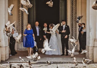 Volo dei piccioni davanti la chiesa con lo stupore dello sposo