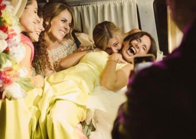 La sposa con le amiche che ridono e si divertono mentre fanno un photobooth
